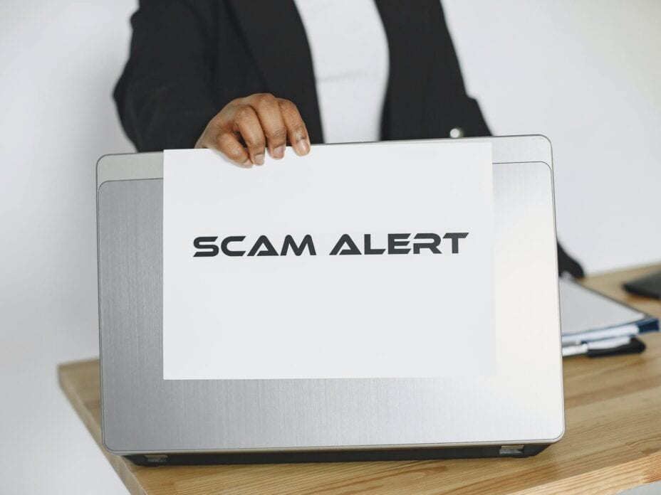 Man Holding a Sheet of Paper on the Laptop